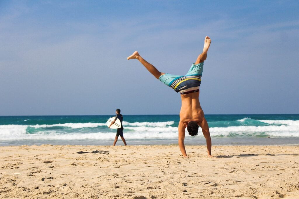 Surfer and beach goer on white sand beach dominican republic