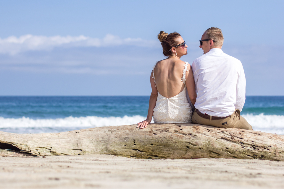  couple sitting on driftwood 