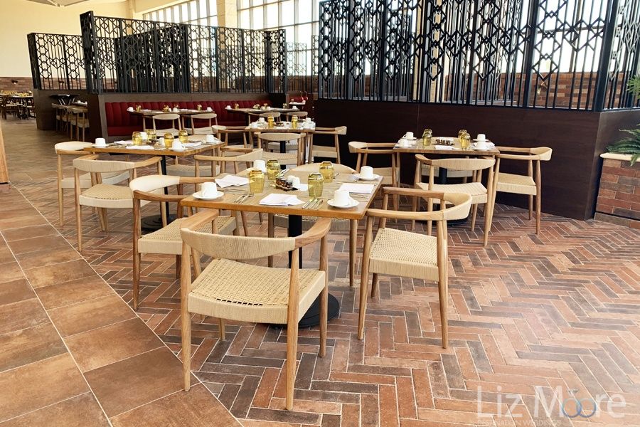 Main buffet area with rattan seating andBlack metal columns and tiled floors