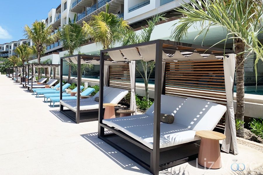Large double sided white cabanas outside on the main deck area by the main buildings