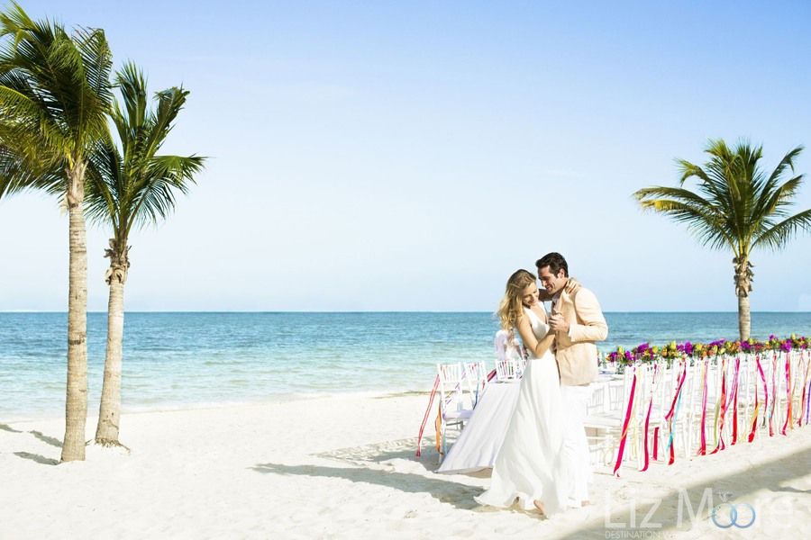 Picture of wedding couple on the beach in bracing with the reception set up on the beach behind them