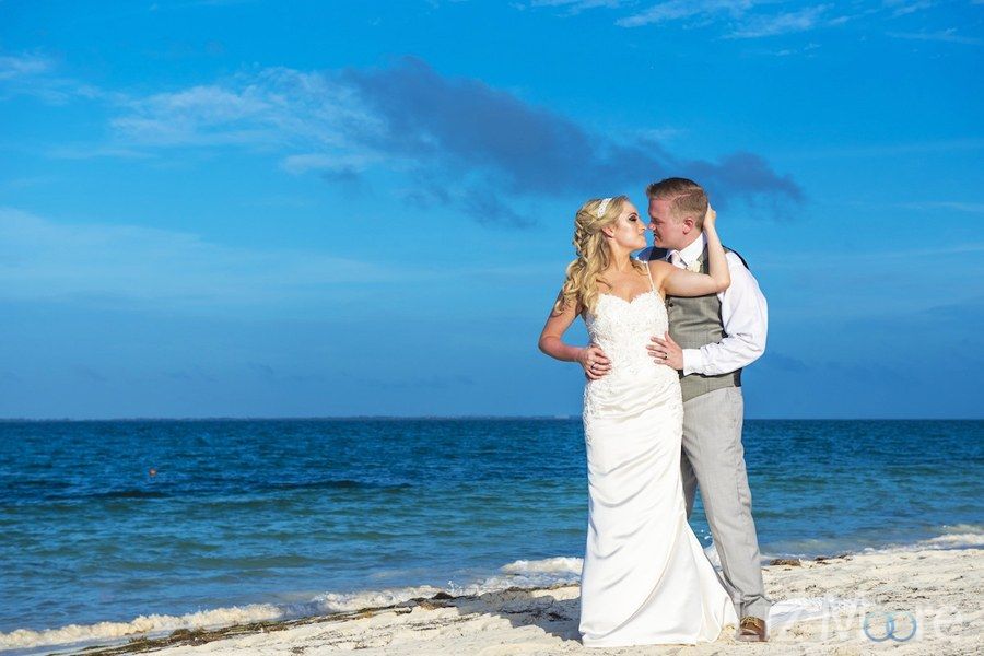 Destination wedding couple and embracing on the beach by the ocean
