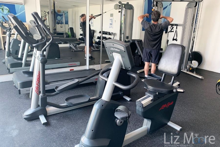 Resort fitness center with guest working out on weight equipment