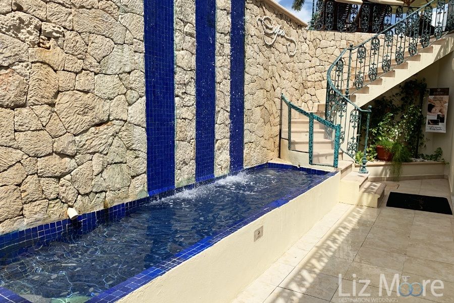 Entrance to the spa with a rock stoneWall and splash pool dark blue