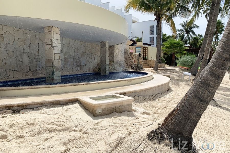 waterfall feature at beach With surrounding white sand and palm trees
