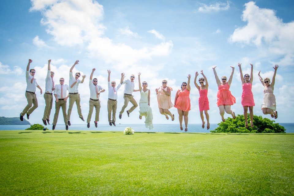 bride and groom jumping up in the air with all their bridesmaids and groomsmen