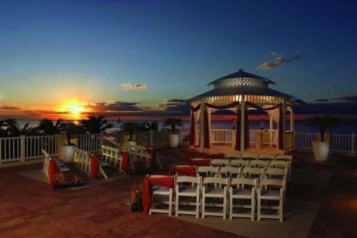 Beautiful wedding gazebo overlooking the ocean in the evening with red decorations
